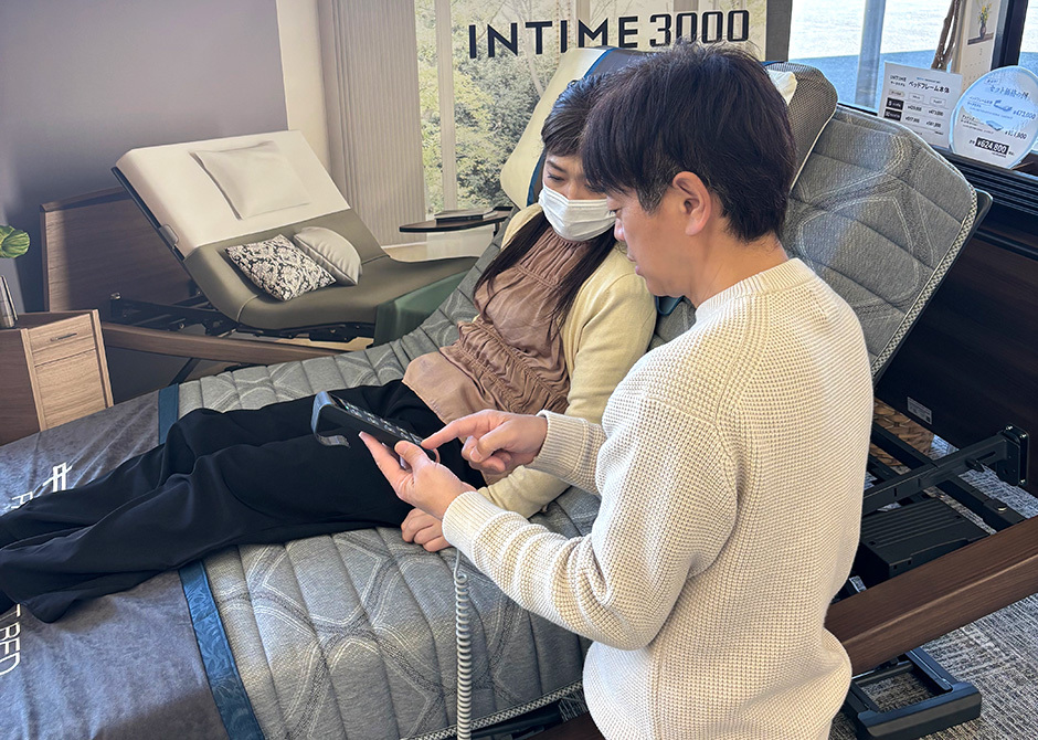 リモコンを手に取って操作方法を伝えるスタッフ
