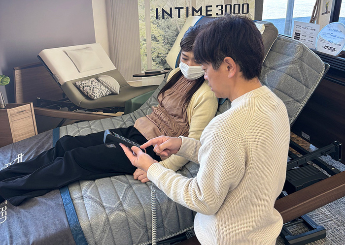 リモコンを手に取って操作方法を伝えるスタッフ